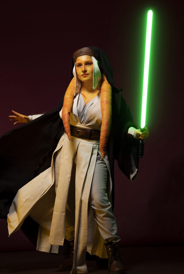 Photo femme en cosplay de star wars, avec un sabre laser vert