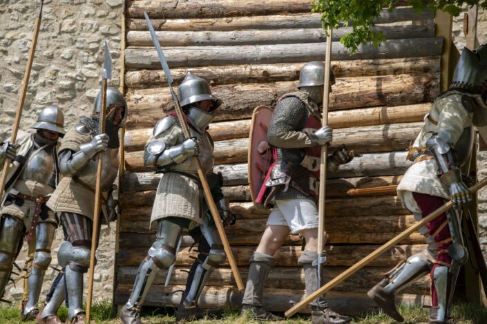 Photo med soldats en armure qui marche le long d'un mur en bois